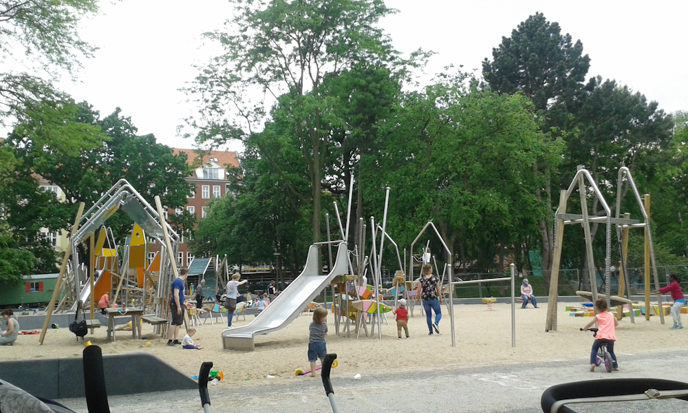 Bild: viele Kinder mit ihren Eltern spieln zwischen Klettergerüsten