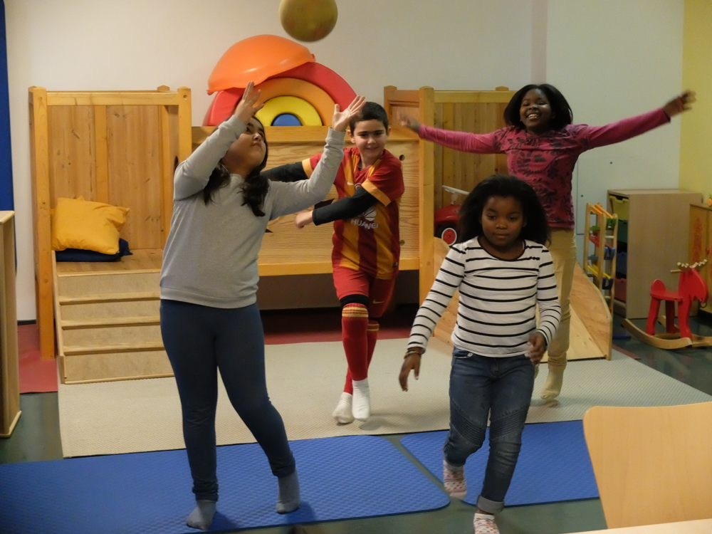 Foto: 3 Mädchen und 1 Junge tanzen, ein Mädchen mit Ball