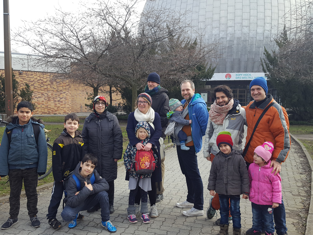 Foto: Eltern und Kinder stehen vor dem Eingang des Carl Zeiss Planetariums. Dir silberne große Kuppel im Hintergrund.