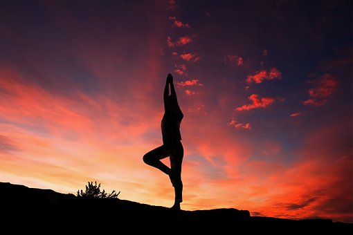 Foto: Frau in Yogapose vor Sonnenuntergang